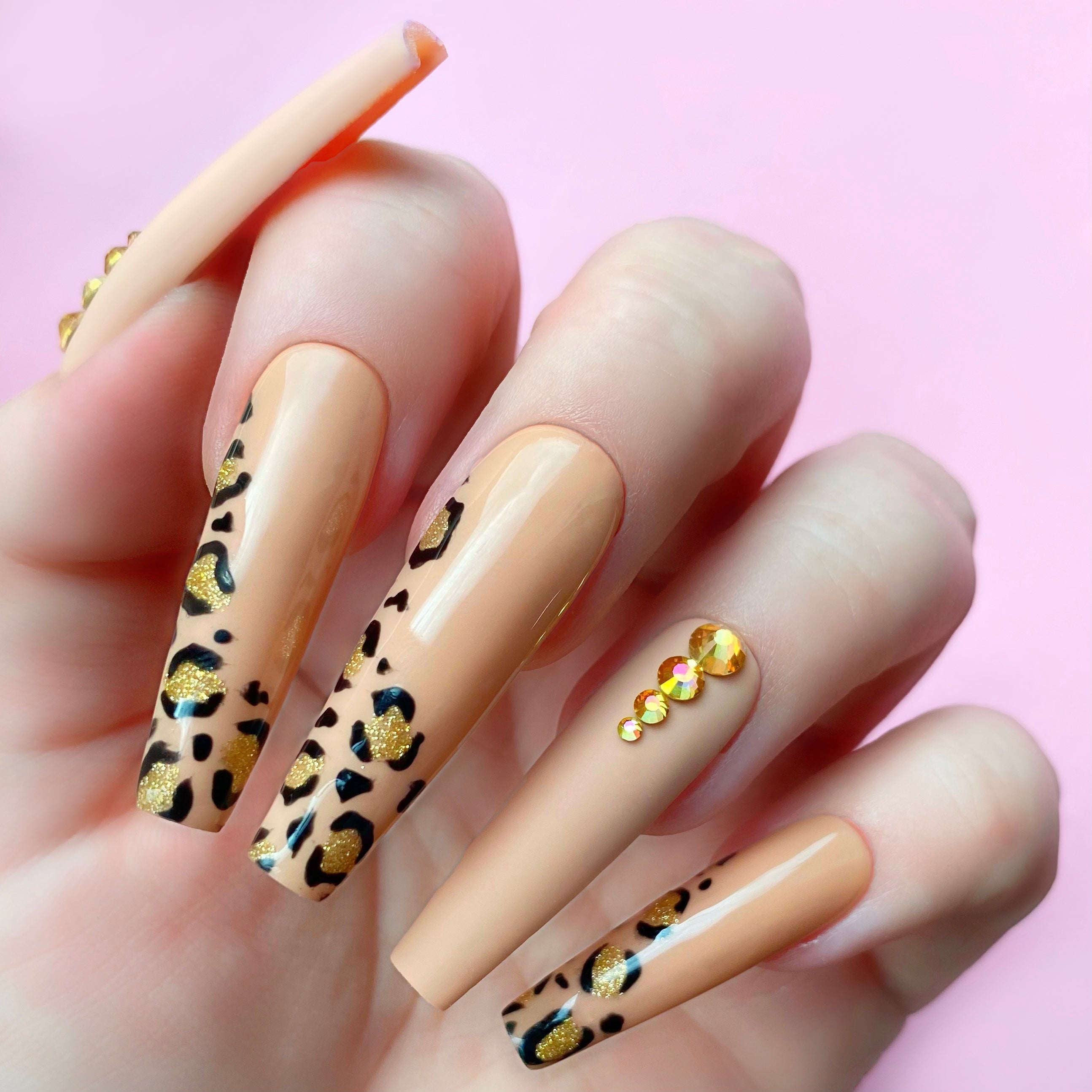 Gold Exhibit gel art bottle applied to nail extension as a cheetah print